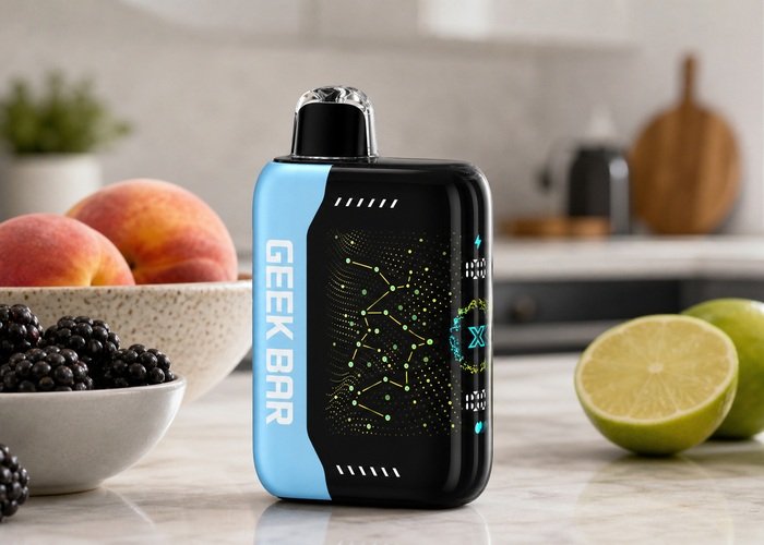 Black and blue Geek Bar Pulse X beside fruit bowls on an adult kitchen counter