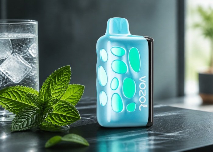 Blue VOZOL Rave 50K Blue Mint beside mint leaves and ice water on an adult kitchen counter