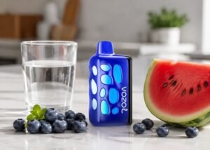 Blue VOZOL Rave 50K Blueberry Watermelon beside blueberries and watermelon and ice water on an adult counter